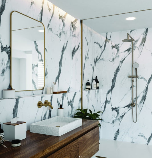 Modern bathroom with marble walls, wooden vanity, and white sink.