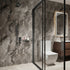 Modern bathroom with stone walls, glass shower enclosure, and wooden vanity.