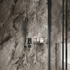Bathroom with marble walls and toiletries on a shelf