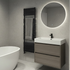 Modern bathroom with a freestanding bathtub, wooden vanity, and round mirror with lighting.